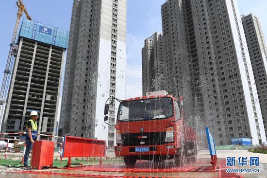 在甘肃省兰州市中建三局一处建设工地上,感应式的洗车台利用循环再生水冲洗车辆,并对污水再次回收利用(5月12日摄)。新华社记者 陈斌 摄