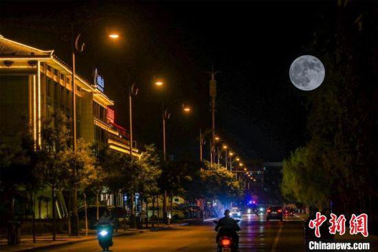 5月26日深夜,一轮超级圆月悬挂在敦煌党河风情线上。(图片为双重曝光)。 王斌银 摄