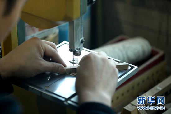 图为团队成员丁延斌用小带锯切割开卯。