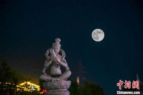 5月26日深夜,一轮超级圆月悬挂在敦煌党河风情线上。(图片为双重曝光)。 王斌银 摄