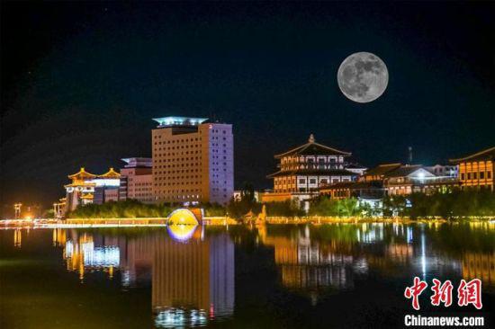 5月26日深夜,一轮超级圆月悬挂在敦煌党河风情线上。(图片为双重曝光)。 王斌银 摄