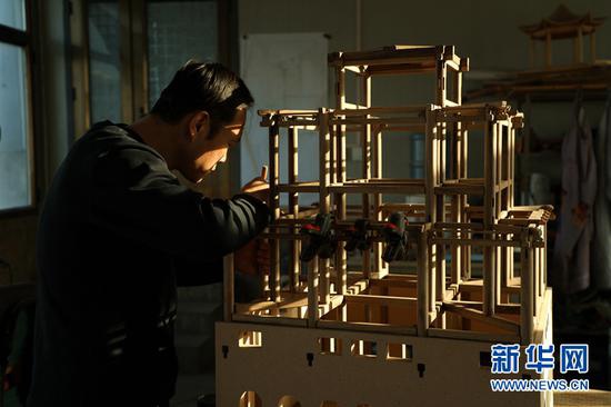 图为团队成员丁延斌在安装平枋。
