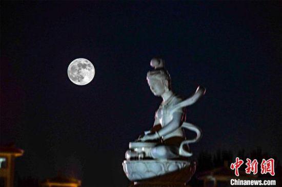 5月26日深夜,一轮超级圆月悬挂在敦煌党河风情线上。(图片为双重曝光)。 王斌银 摄