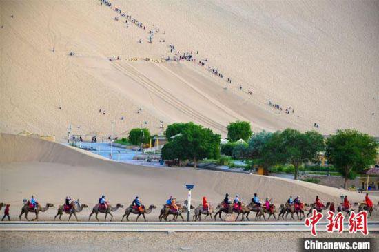 6月13日,敦煌鸣沙山月牙泉景区热闹非凡。 王斌银 摄