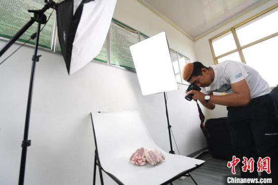 张忠山自学摄影技术,给产品拍照。 杨艳敏 摄