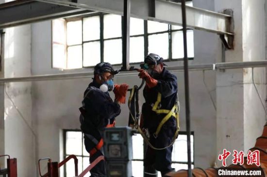7月,暑运期间,在高达35℃的室外温度下,洗罐工的“行头”却与这个夏日“格格不入”。 陶飞 摄