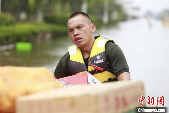 图为贺乐在抗洪一线搬运救灾物资。 霍亚平 摄