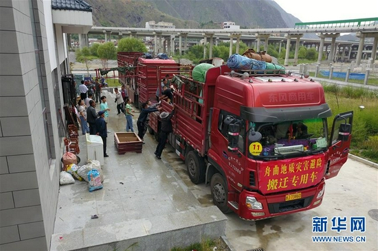在舟曲县地质灾害避险搬迁首批搬迁群众转运点，工作人员将搬迁群众物品装车（8月6日摄，无人机照片）。新华社记者 范培珅 摄