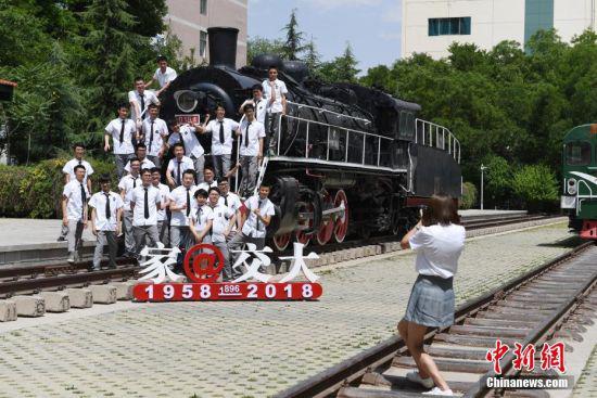 6月12日,兰州交通大学校园内的蒸汽机火车头吸引大学生拍摄怀旧毕业照。中新社记者 杨艳敏 摄