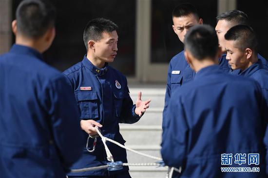 李志亮与队友交流绳索救援经验(4月11日摄)。 新华社记者 陈斌 摄