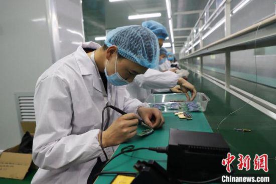 图为工人们在电子测温枪生产线上进行安装作业。 刘枫 摄