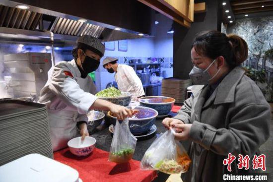 图为日前返回兰州的务工人员,为食客打包牛肉面。 杨艳敏 摄