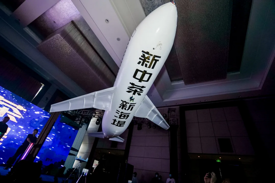 ▲印着“新中茶 新海堤”字样的飞机模型从会场起飞