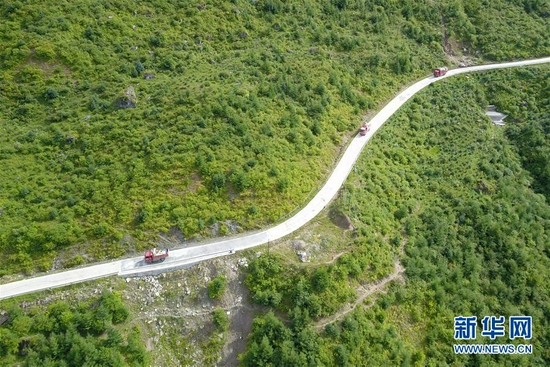 这是8月5日在舟曲县果耶镇境内拍摄的满载物品的搬家车辆行驶在山间道路上（无人机照片）。新华社记者 范培珅 摄