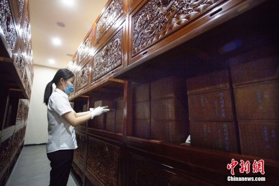 8月17日,甘肃省兰州市天庆博物馆的工作人员在整理该馆收藏的文渊阁版《四库全书》影印本。中新社记者 高展 摄