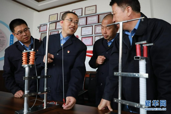 8月17日,石瑾(左二)和同事在模型前对自主研制的设备进行改进探讨。新华社记者 杜哲宇 摄