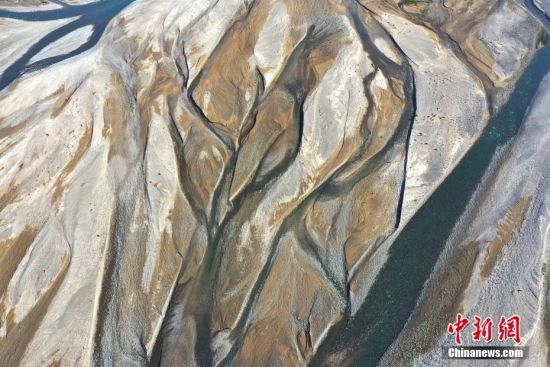 8月27日，俯瞰甘肃省酒泉市疏勒河河道，河流曲线与泥沙相间，色彩奇妙，好似油画。 中新社发 吴学珍 摄 图片来源：CNSPHOTO