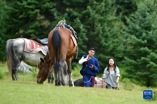 游客在扎尕那景区内身着藏族服饰游览（8月28日摄）。新华社记者 陈斌 摄