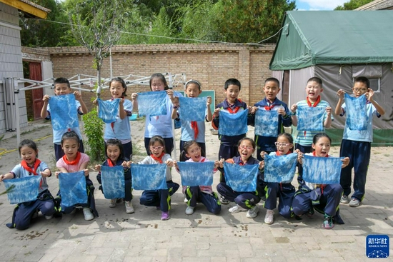    9月2日，渭州学校的学生们展示自己的扎染作品。新华社发（王紫轩 摄）