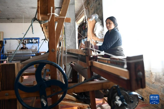 加科村村民周毛吉使用传统木式纺织机编织手工艺品（9月9日摄）。新华社记者 陈斌 摄