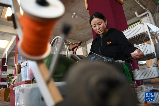 加科村村民旦真吉在藏族手工艺品车间里纺线（9月9日摄）。新华社记者 陈斌 摄