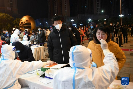 10月21日凌晨,在兰州市城关区天水路一核酸检测采样点,市民有序排队接受核酸采样。新华社 范培珅 摄