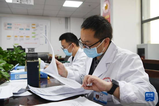 10月29日,在兰州市疾病预防控制中心,流调人员查看协查函。新华社记者 范培珅 摄
