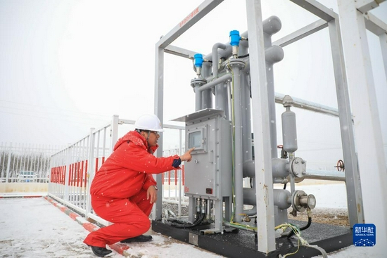 12月10日，在位于甘肃省庆阳市华池县的长庆油田国家级页岩油开发示范区华H60平台，工作人员在设置油井自动计量装置的参数。新华社记者 马希平 摄