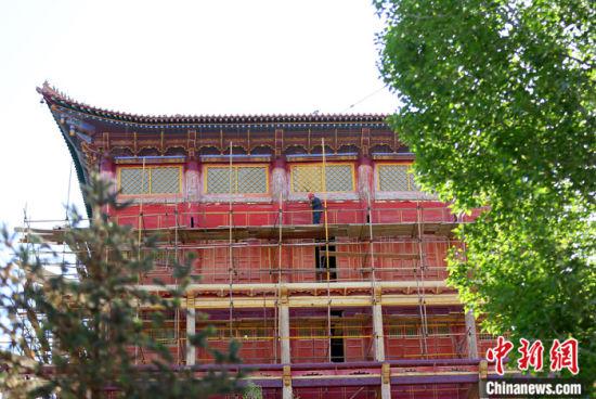 图为5月上旬,甘肃山丹县大佛寺内,工作人员对古建筑大雄宝殿进行修缮。 中新社记者 高展 摄