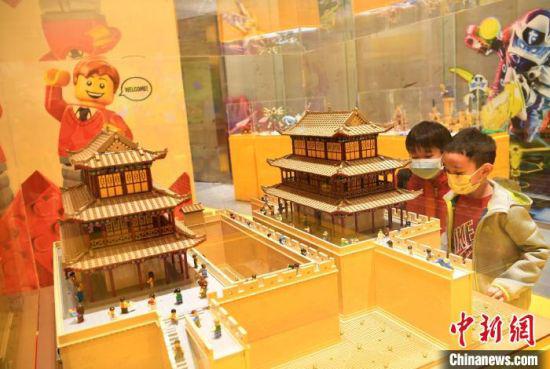 图为两个小孩欣赏乐高搭建的嘉峪关3D模型。 杨艳敏 摄