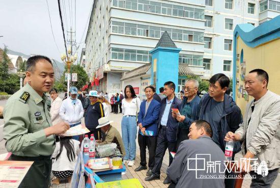图为宕昌县人武部政委胡义文为家长答疑解惑。