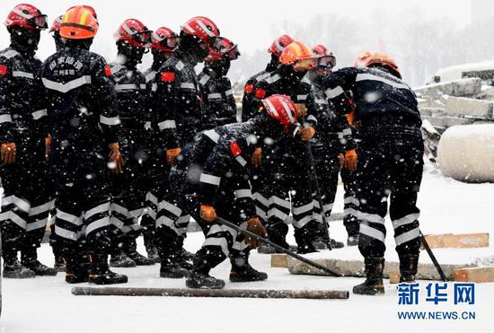 12月22日,甘肃森林消防员在兰州国家陆地搜寻与救护训练基地,冒着风雪严寒开展综合应急救援技能训练。