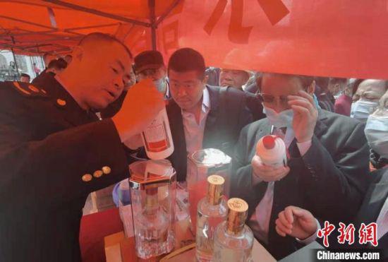 图为市场监管局工作人员提醒民众甄别假冒侵权商品。 史静静 摄