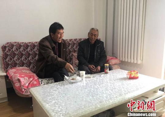 蔡希龙与老同学杨克胜之前住大山的时候两村相距1小时山路,小学毕业40年间几乎没见过面。但是,由于去年底他们都住进同一幢新楼房,现在见面的机会也多了,没事还能互相串门。 张婧 摄