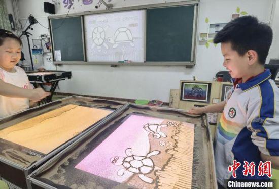 图为七里河小学学生创作沙画。 高展 摄