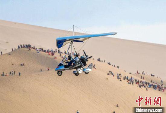 图为游客乘坐滑翔机从空中鸟瞰大漠美景。 王斌银 摄