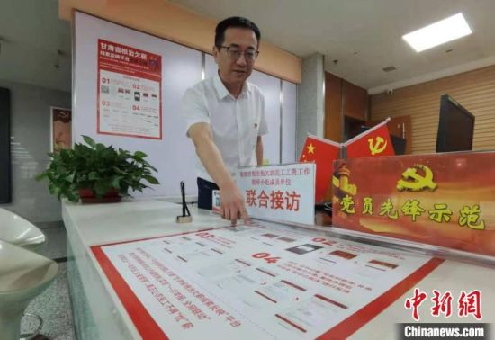 图为甘肃省人社厅劳动保障维权中心主任李军介绍根治欠薪线索反映平台的使用方法。 张婧 摄