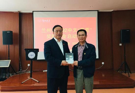 河北省作家协会副主席刘建东(右)向兰州大学党委书记袁占亭(左)赠送他新创作的文学作品。(兰州大学文学院供图)