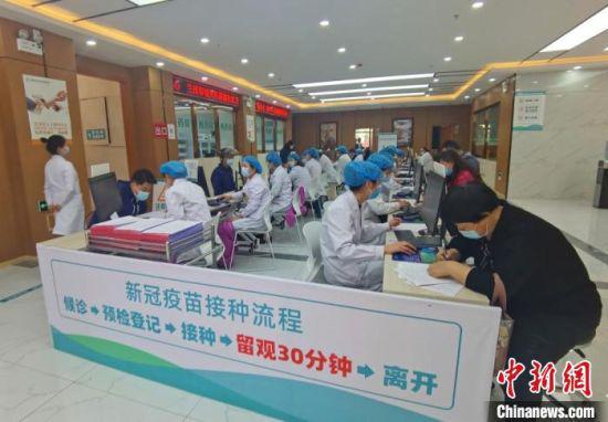 图为城关区雁南街道社区卫生服务中心接种点,医护人员登记、录入接种人员的信息。 闫姣 摄