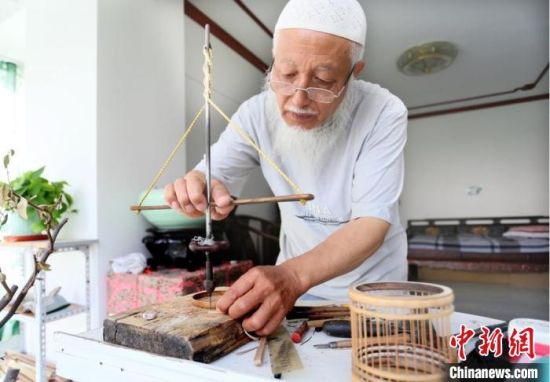 7月中旬,甘肃天水市“竹雕大师”吴云生借助工具手工打眼。 高展 摄