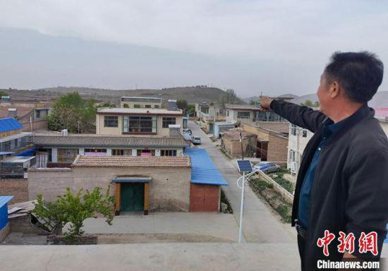 图为梁培智介绍这些年村貌的变化。 刘玉桃 摄