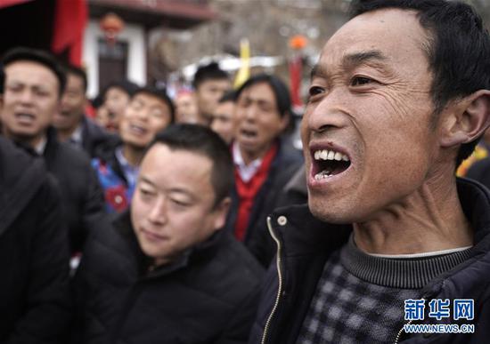 2月19日,在甘肃省陇南市武都区马街镇姜家山村,几名男子在社火队表演时大声唱起当地的歌谣。 新华社记者 才扬 摄