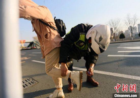为做好防护工作,每每有医护人员乘坐摩托车时,张卫星都会给乘客衣物和鞋底喷洒消毒液。 闫姣 摄