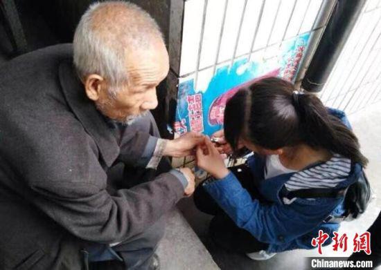 图为大学生志愿者帮老人剪指甲。(资料图) 兰州交通大学供图