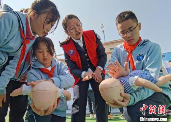 图为兰州市小学生在救援中心专业人员指导下练习急救技能。 闫姣 摄