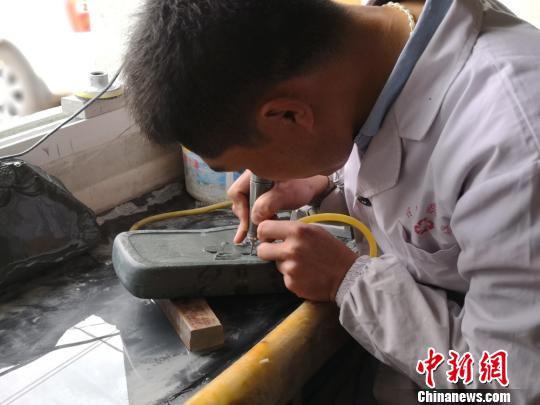 图为黄炳强用工具进行粗略地雕刻。 杨娜 摄