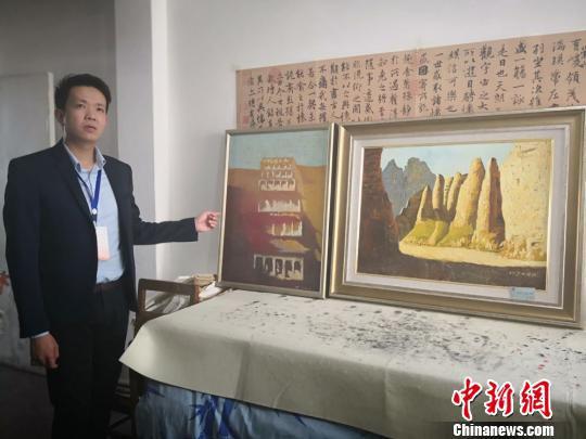 图为牛浩东介绍他的绘画代表作品《敦煌印象》与《黄河石林》。 崔琳 摄