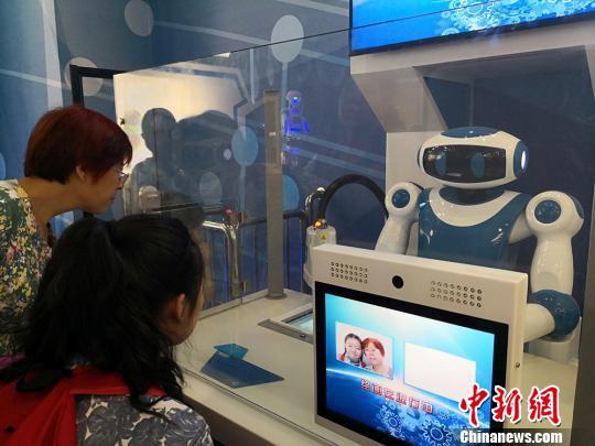 图为家长和孩子体验绘画机器人,将两人合影画出来,定格“幸福瞬间”。 魏建军 摄