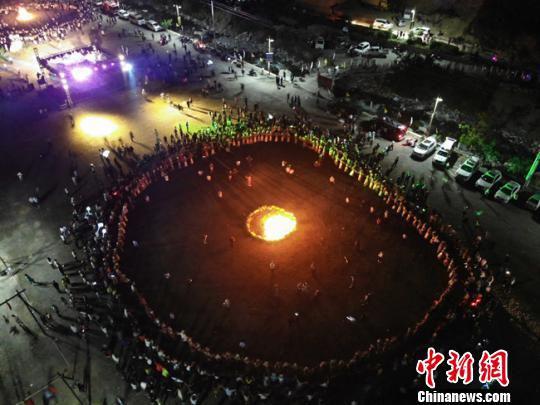 图为白马人手牵手围着篝火一边高歌一边跳舞。 杨艳敏 摄