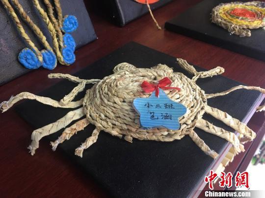 图为当地学生用草绳编织的“螃蟹”手工艺作品展示。 张婧 摄